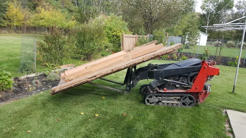 Fence panels being carried out by machine during a removal